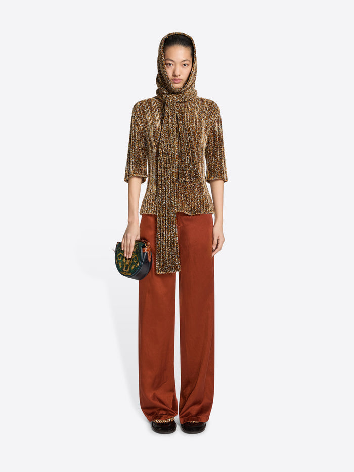 Person wearing a handbag with decorative pattern on a white background