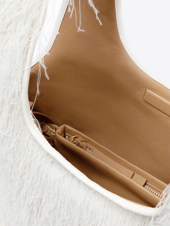 Close-up of a brown leather bag with a white interior on a light background