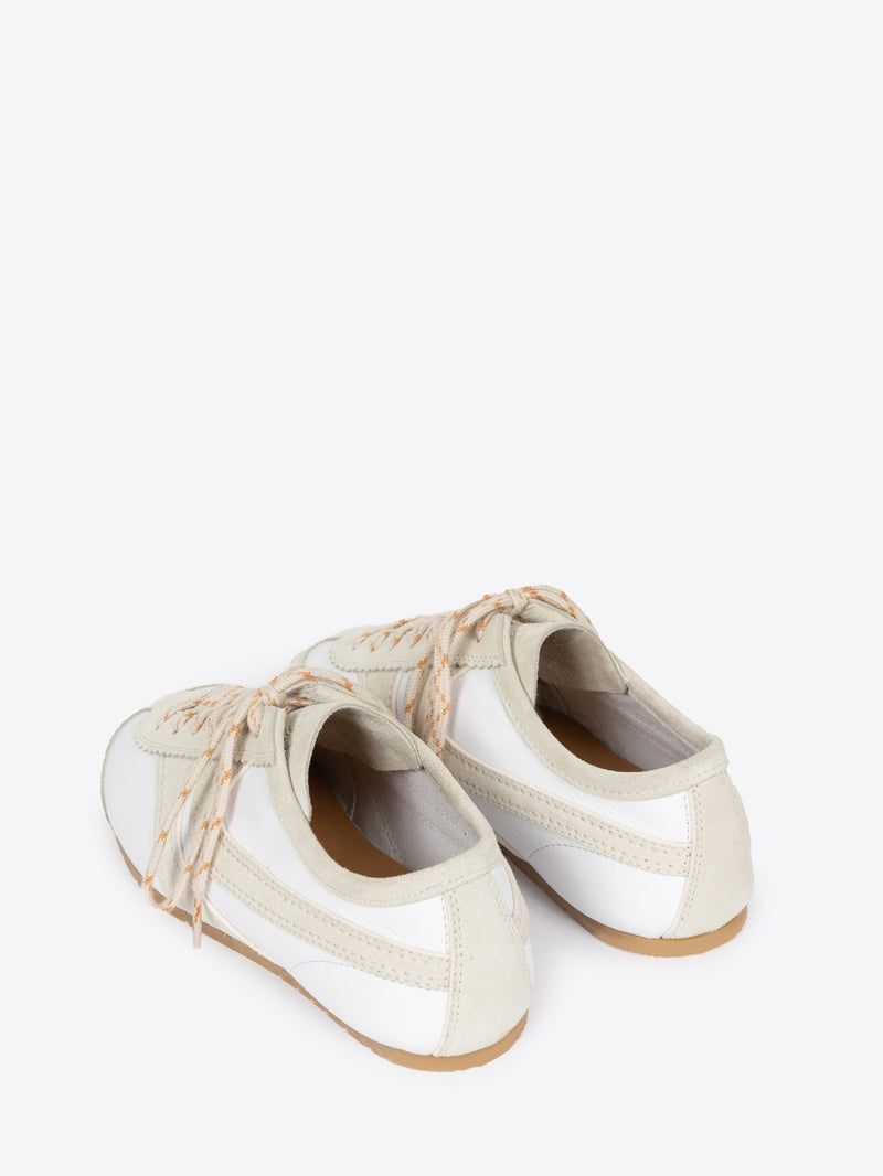 Backside of a pair of white, with beige accents, suede sneakers on a white background
