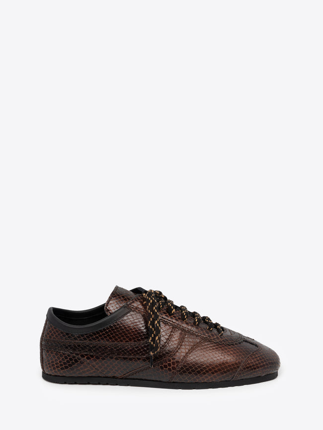 Brown suede sneaker with snake pattern on a white background