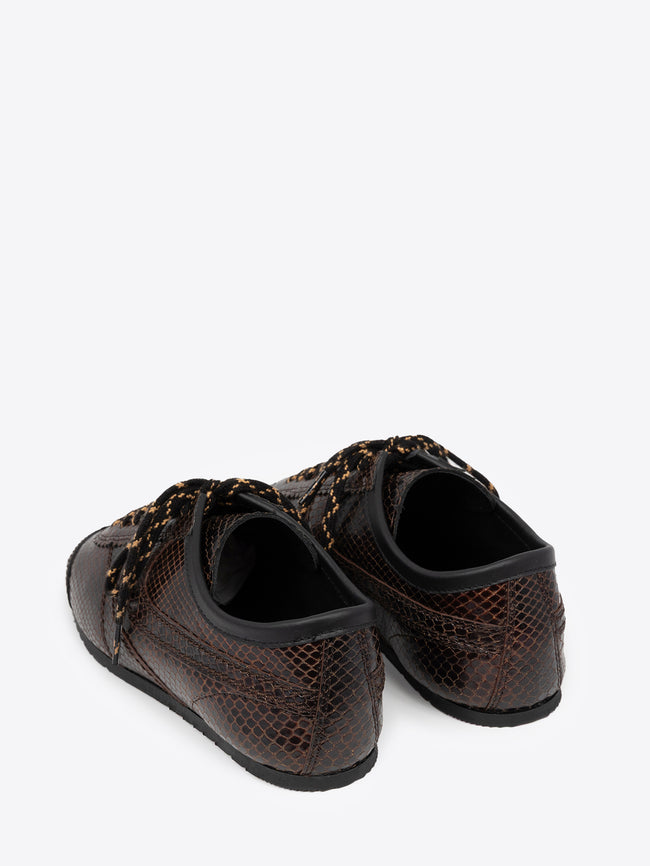 Backside of a pair of brown suede sneakers with snake pattern on a white background