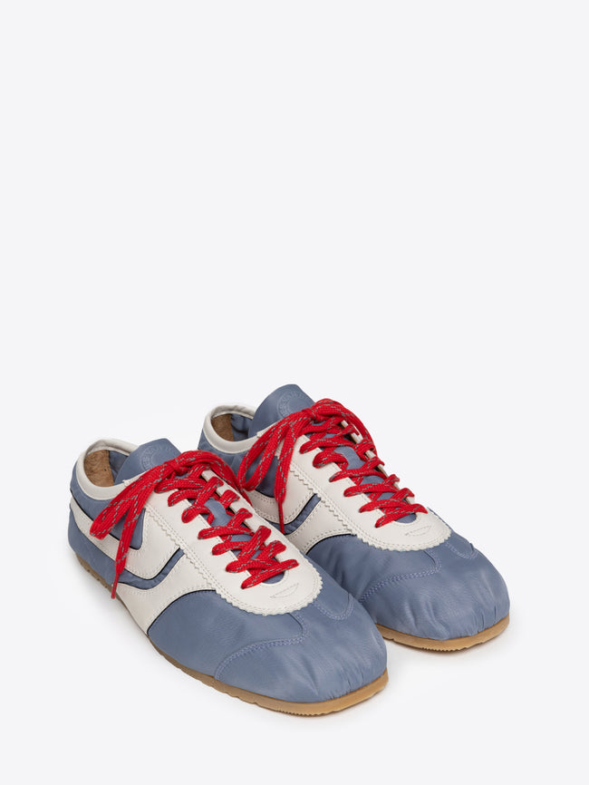 Pair of light blue nylon sneakers with red laces on a white background
