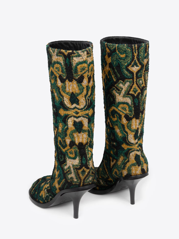 Backside of a pair of green, yellow and black patterned round-toe, stiletto heel jacquard boots on a white background