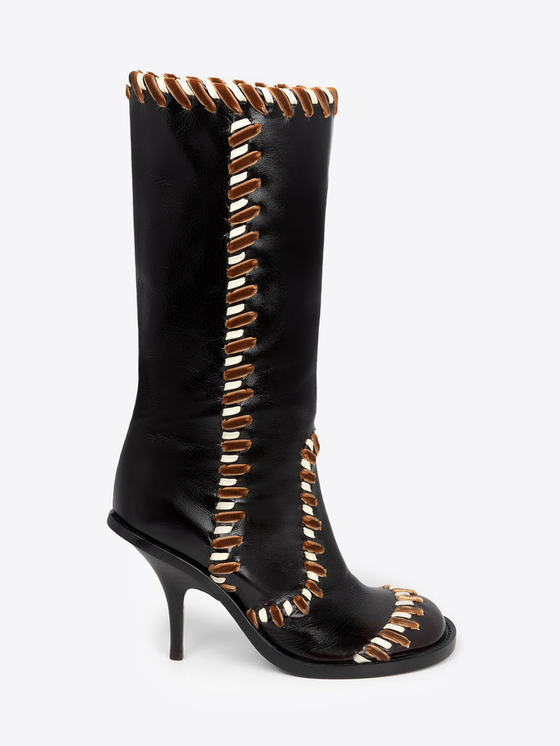 Black knee-high boot with gold accents on a white background