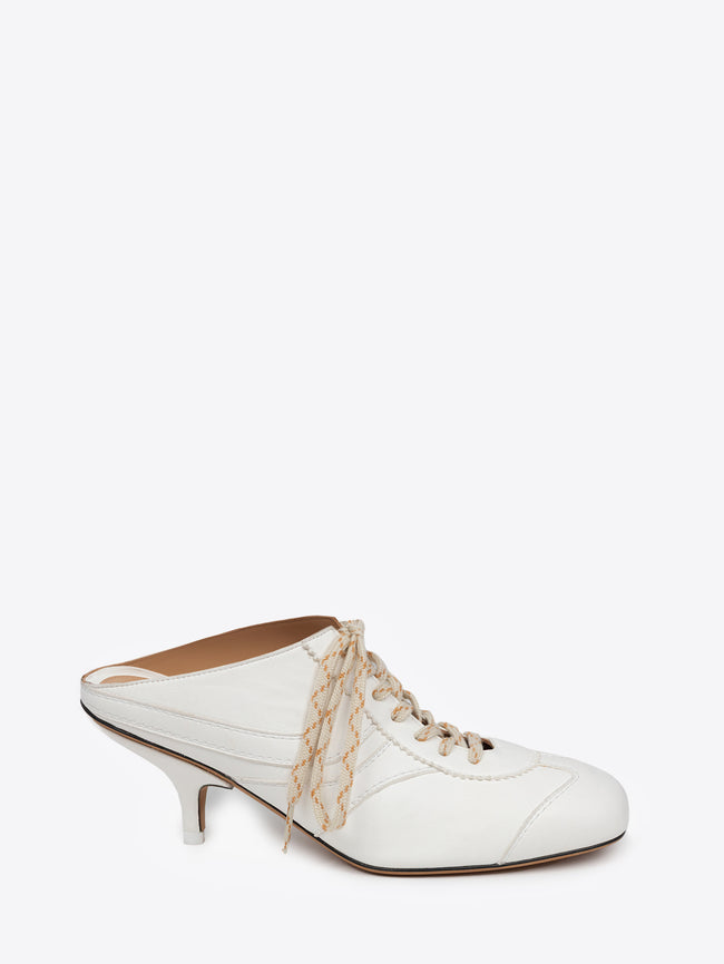 White shoe with a thin heel and lace detail on a white background