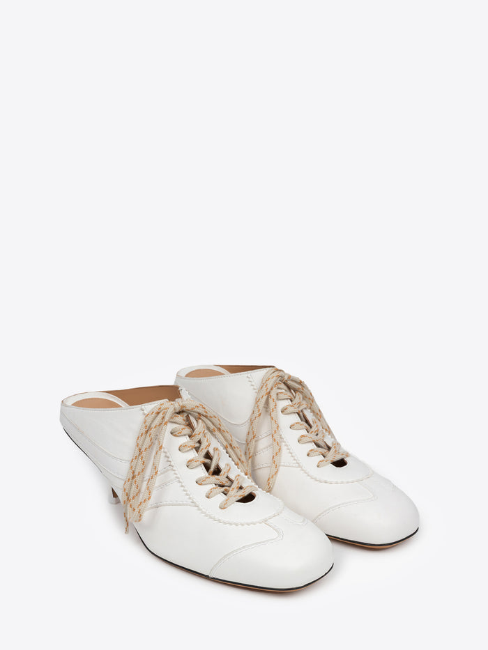 White shoe with a thin heel and lace detail on a white background