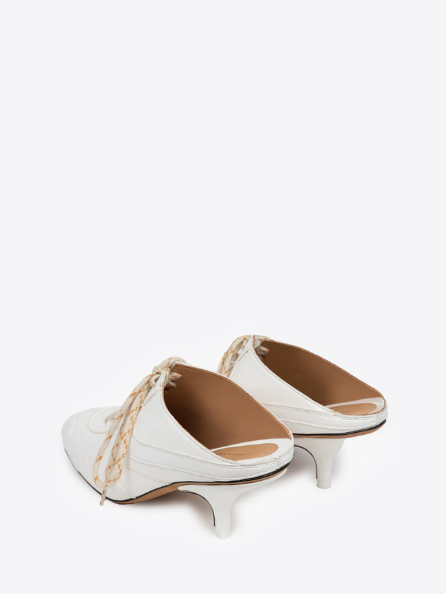White shoe with a thin heel and lace detail on a white background