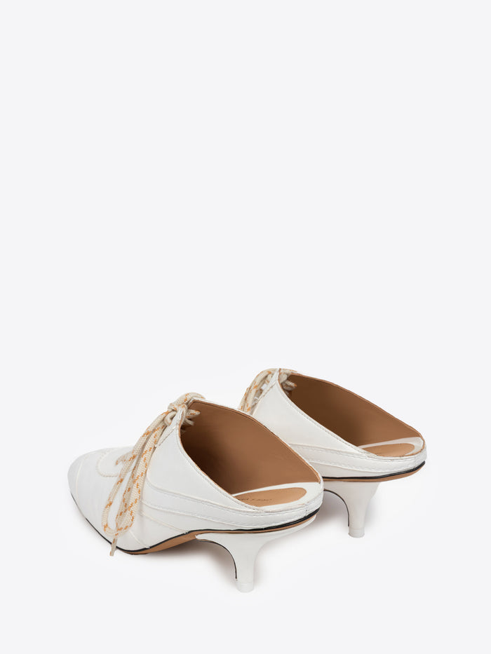 White shoe with a thin heel and lace detail on a white background