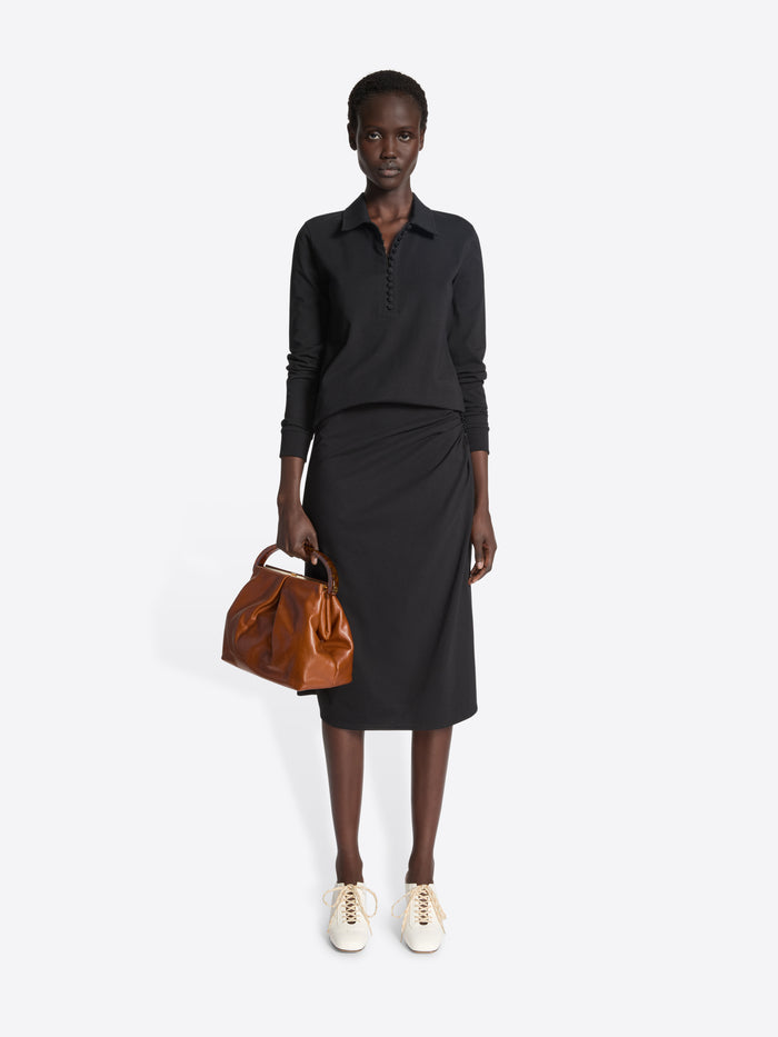 Person wearing a white shoe with a thin heel and lace detail on a white background