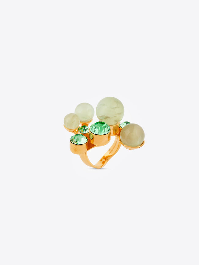 Gold ring with green and clear gemstones on a white background