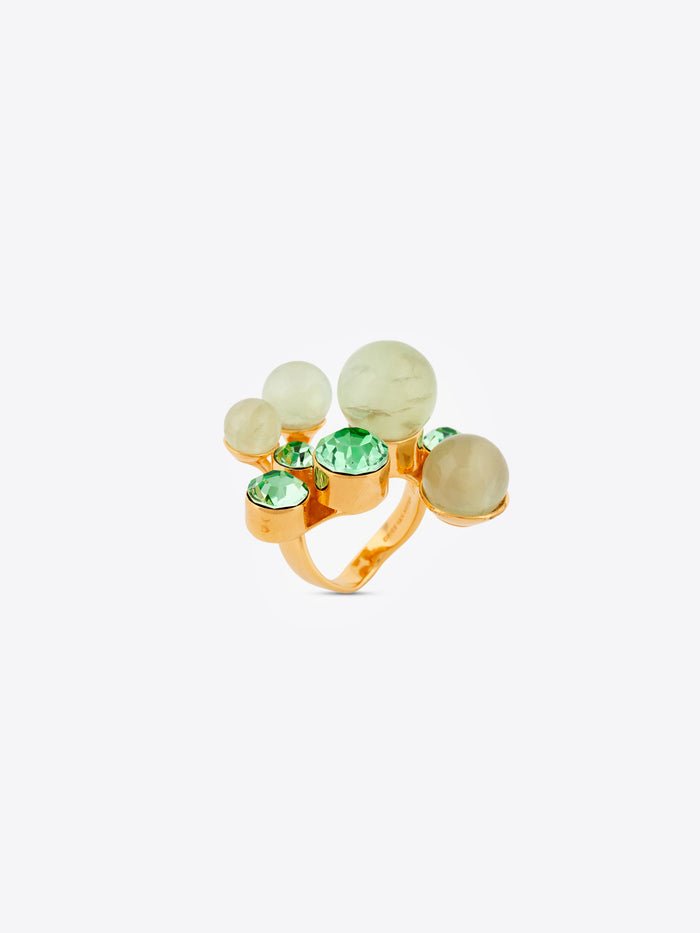 Gold ring with green and clear gemstones on a white background