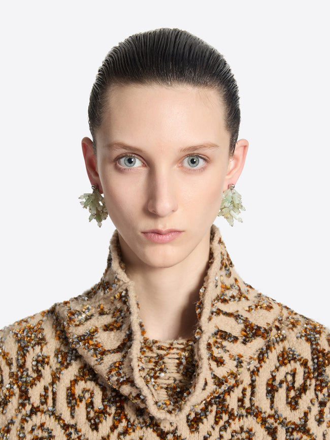 Woman wearing a patterned coat with a plain background