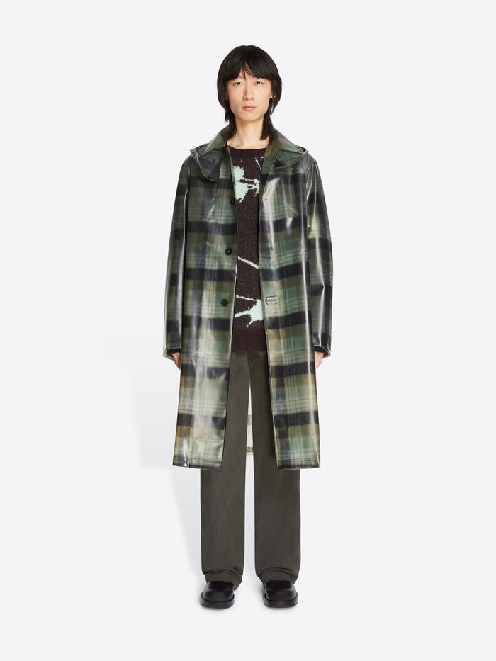Person wearing a long plaid coat on a white background