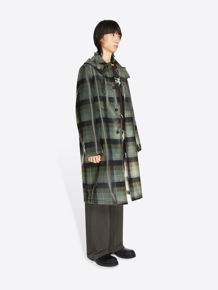 Person wearing a green plaid coat on a white background