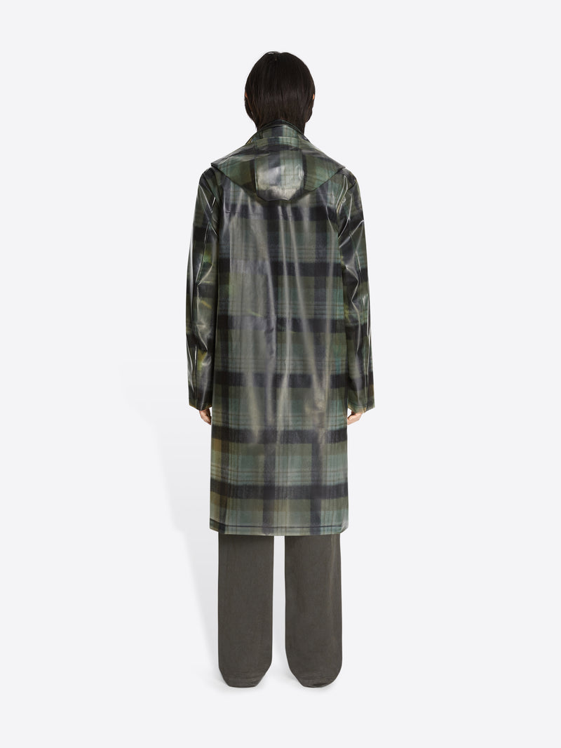 Person wearing a green plaid coat on a white background