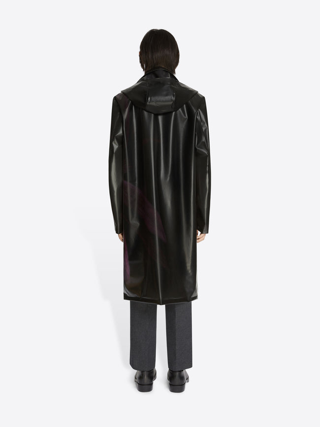Person wearing a black raincoat on a white background