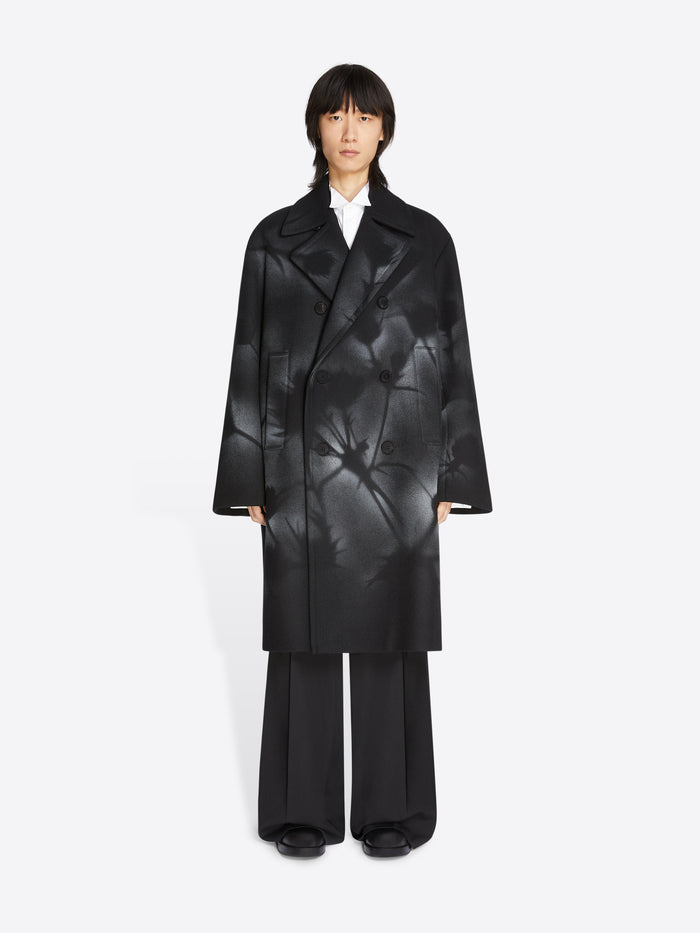 Person wearing a black textured coat on a white background