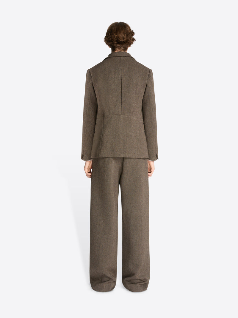 Backside of a model wearing a brown cropped suit jacket and matching pants on a white background