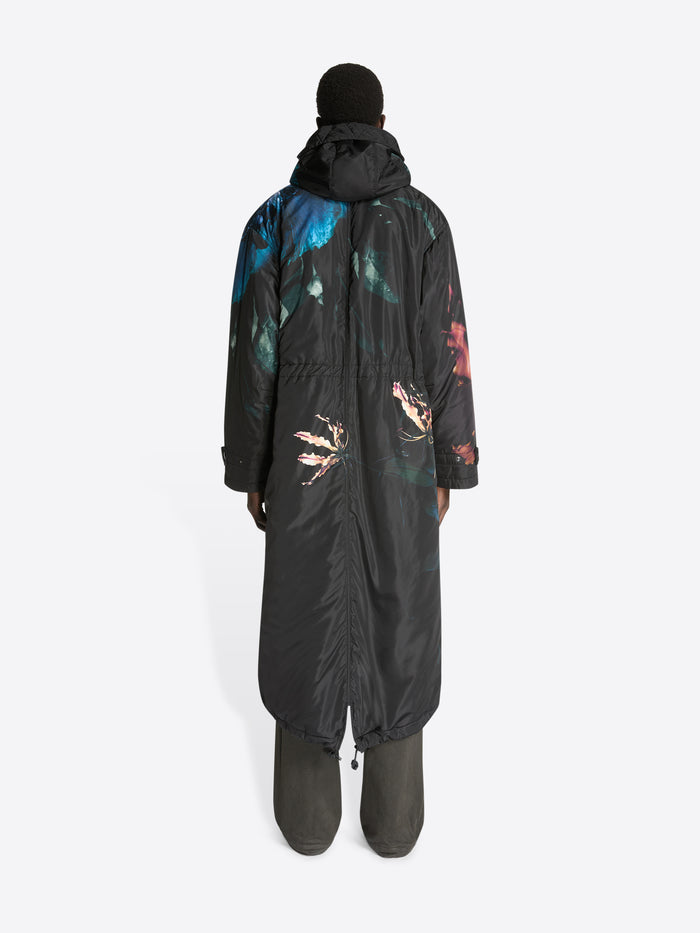 Person wearing a black snowsuit with colorful designs on a white background