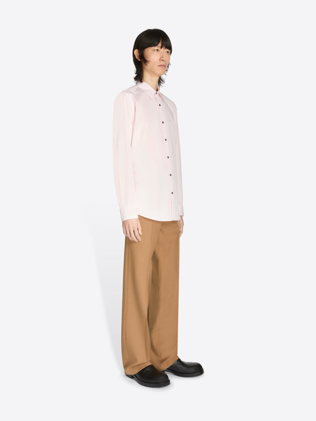 Person wearing a light pink shirt on a white background