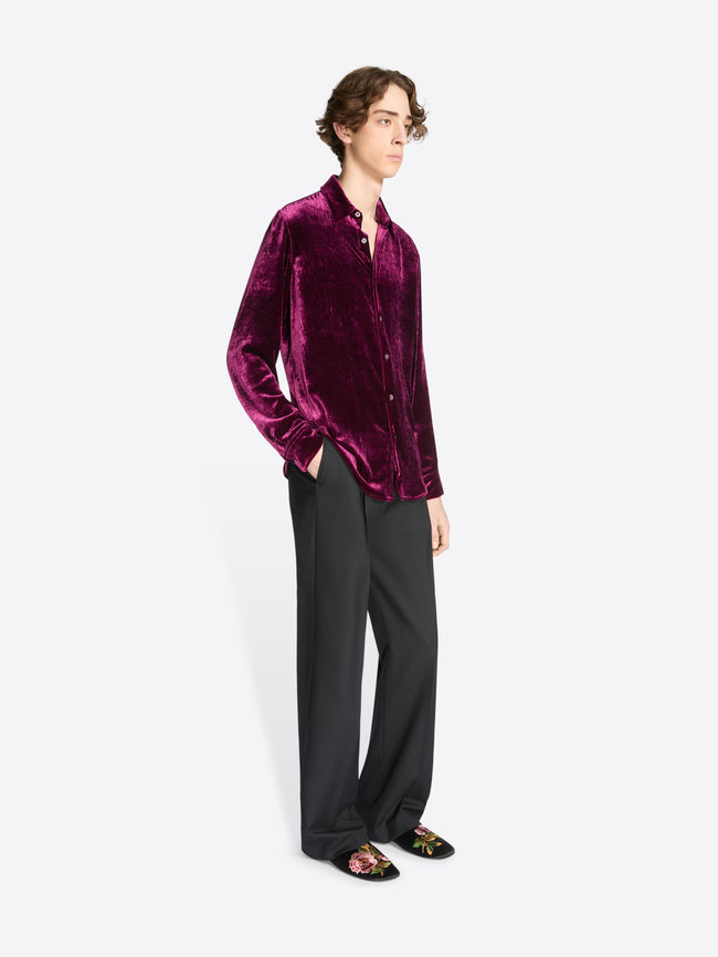 Person wearing a violet velvet shirt on a white background