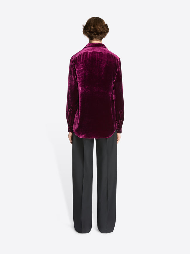 Person wearing a violet velvet shirt on a white background