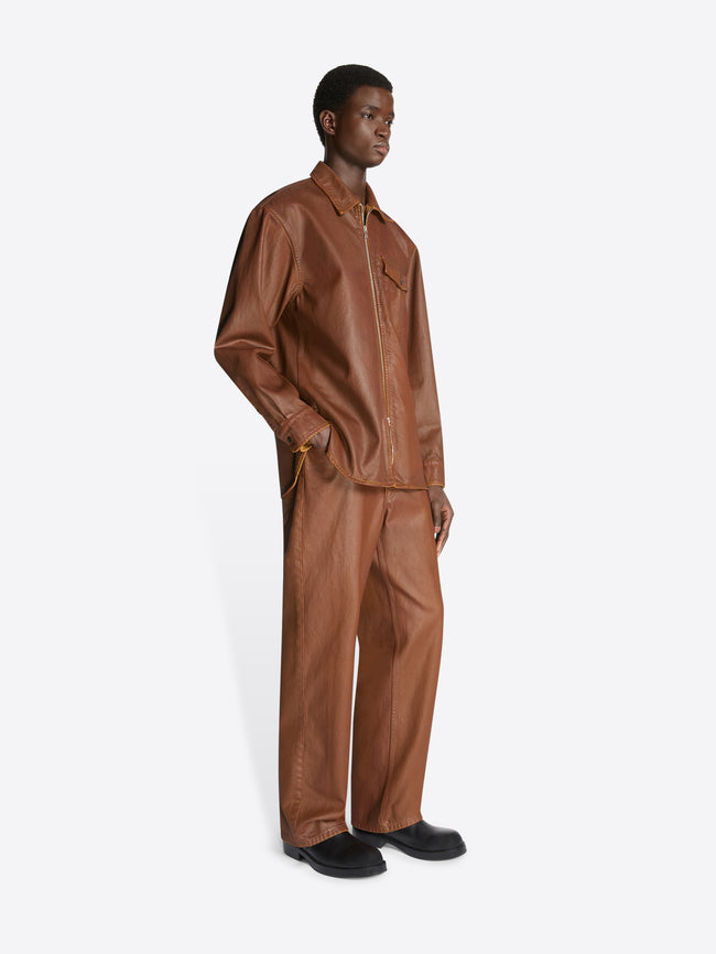 Model wearing a rust colored coated zipped shirt and matching pants on a white background