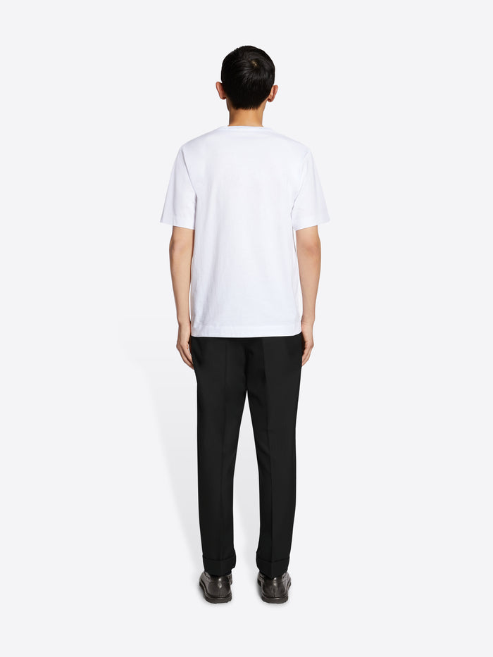 Person wearing a white t-shirt and black pants on a white background
