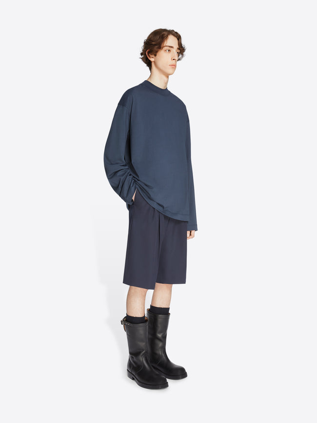 Model wearing a navy colored long sleeve tee and navy shorts on a white background