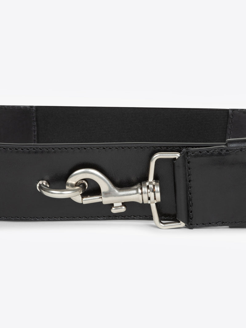 Close-up of a black belt with a silver buckle on a white background