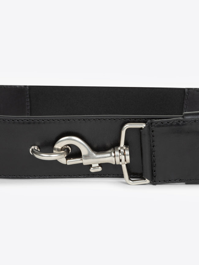 Close-up of a black belt with a silver buckle on a white background