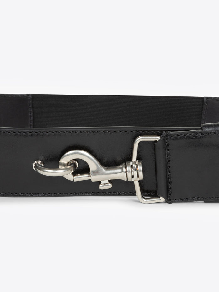 Close-up of a black belt with a silver buckle on a white background