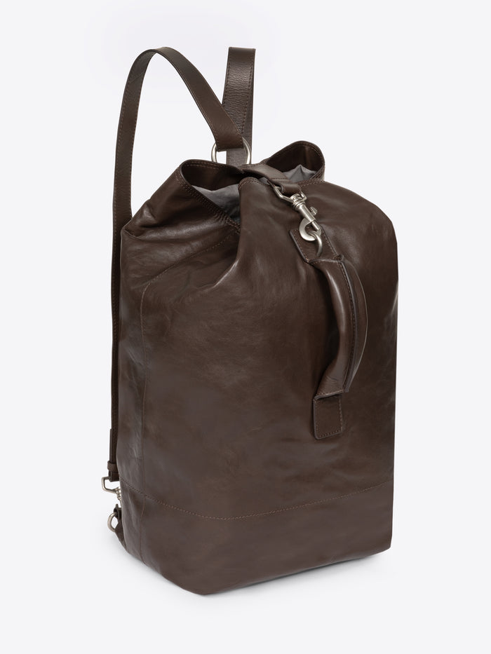 Brown, adjustable leather bag with a front clasp on a white background