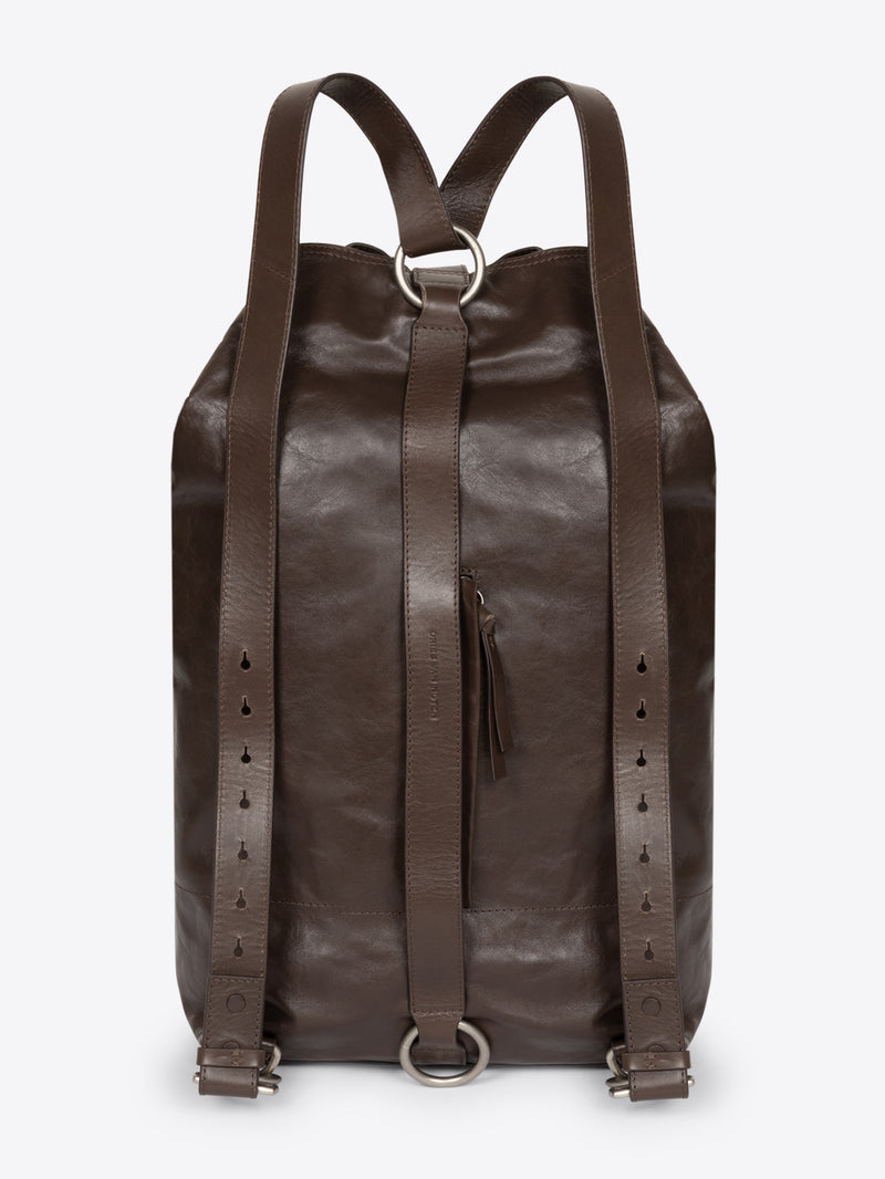 Backside of a brown, adjustable leather bag with a front clasp on a white background