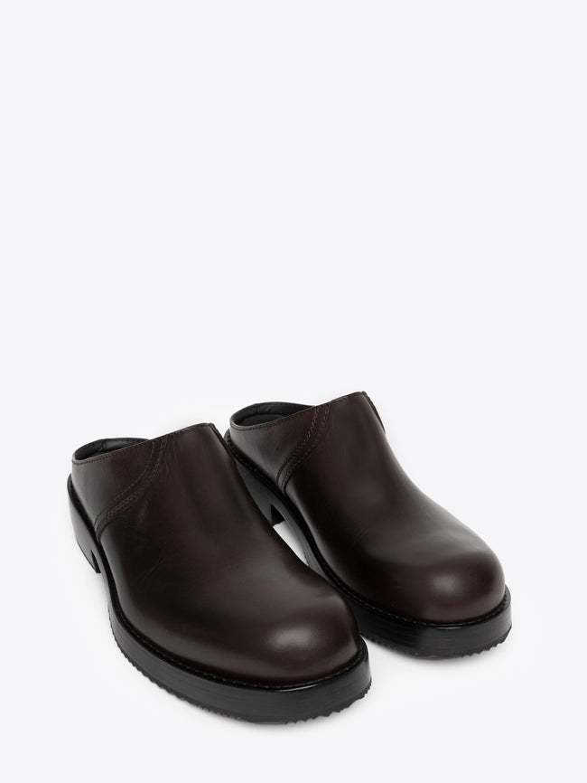 Pair of dark brown leather clogs on a white background