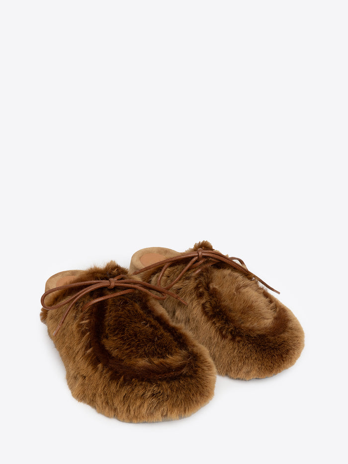 A pair of tan fluffy slippers on a white background