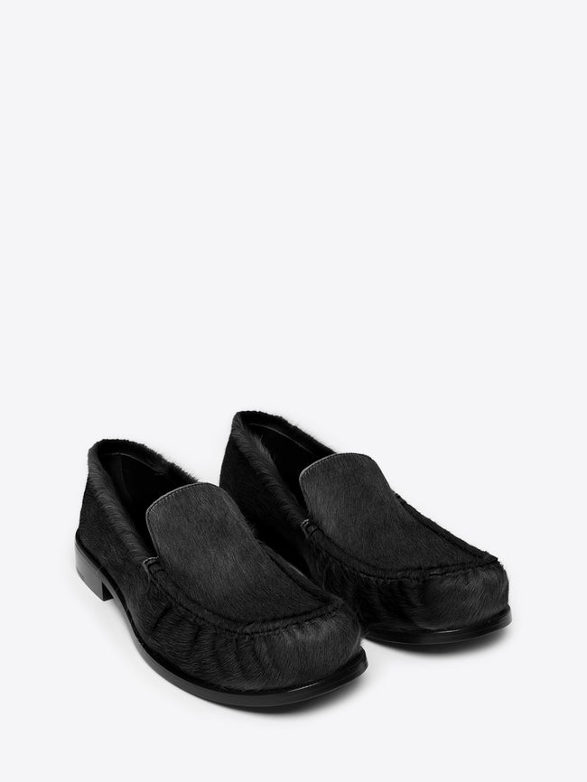 Pair of black leather loafer shoes on a white background