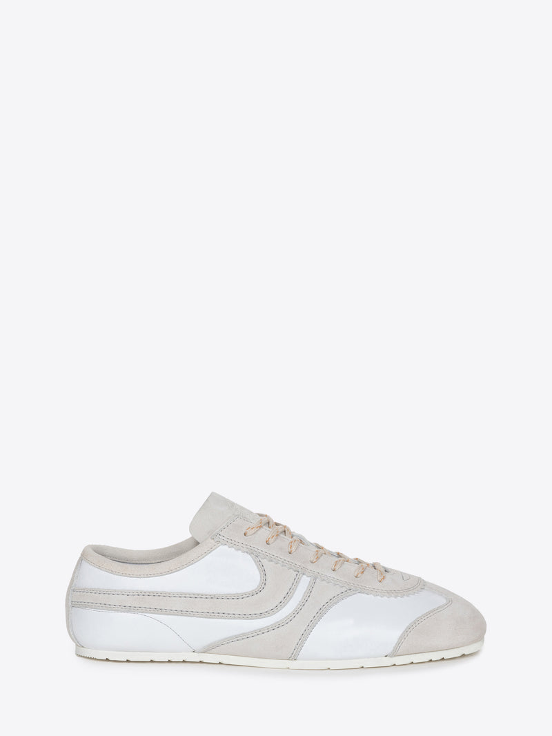 White suede sneaker with beige accents on a white background