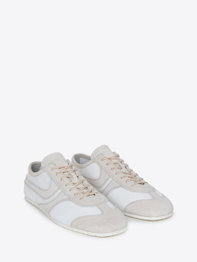 Pair of white suede sneakers with beige accents on a white background