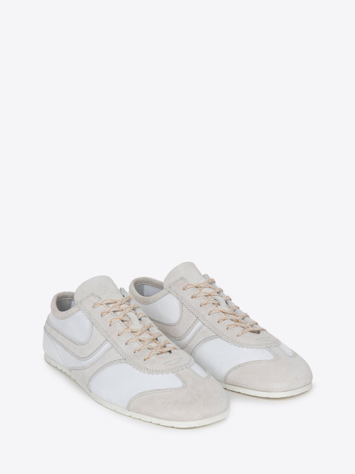 Pair of white suede sneakers with beige accents on a white background