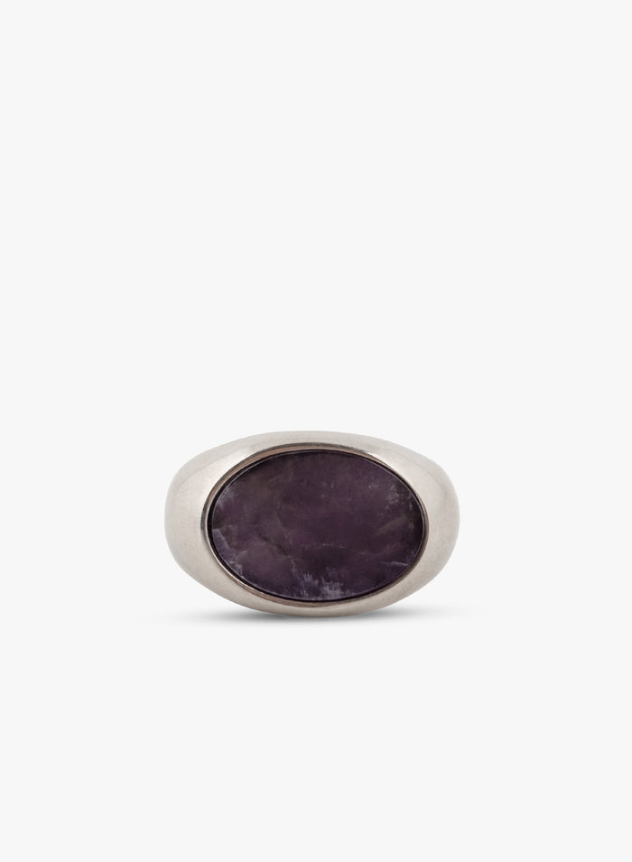 Front view of a silver ring with a flat dark purple stone on a white background