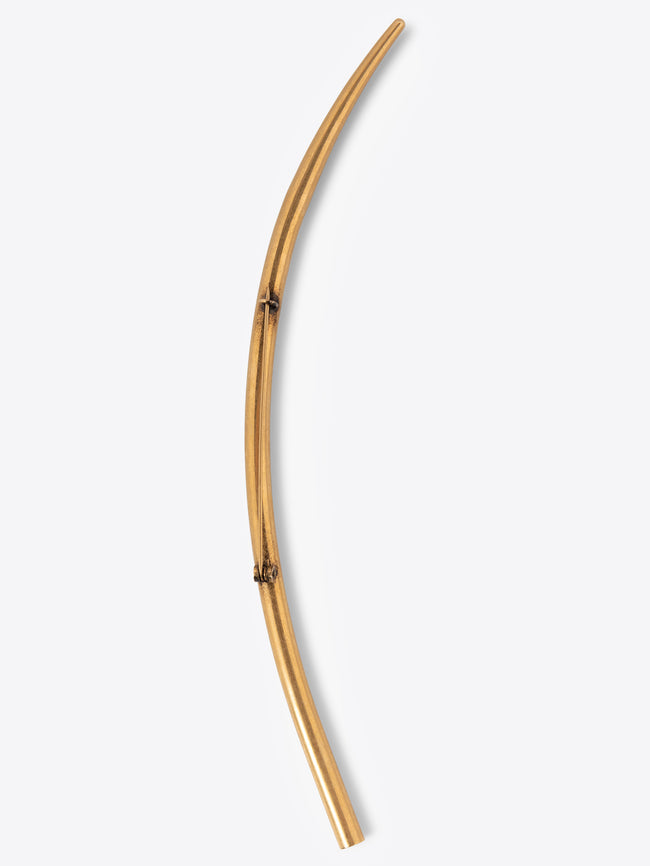 Long curved mat gold brooch on a white background