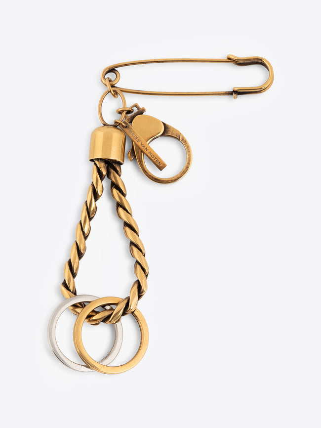 Gold keychain with a safety pin and two rings on a white background