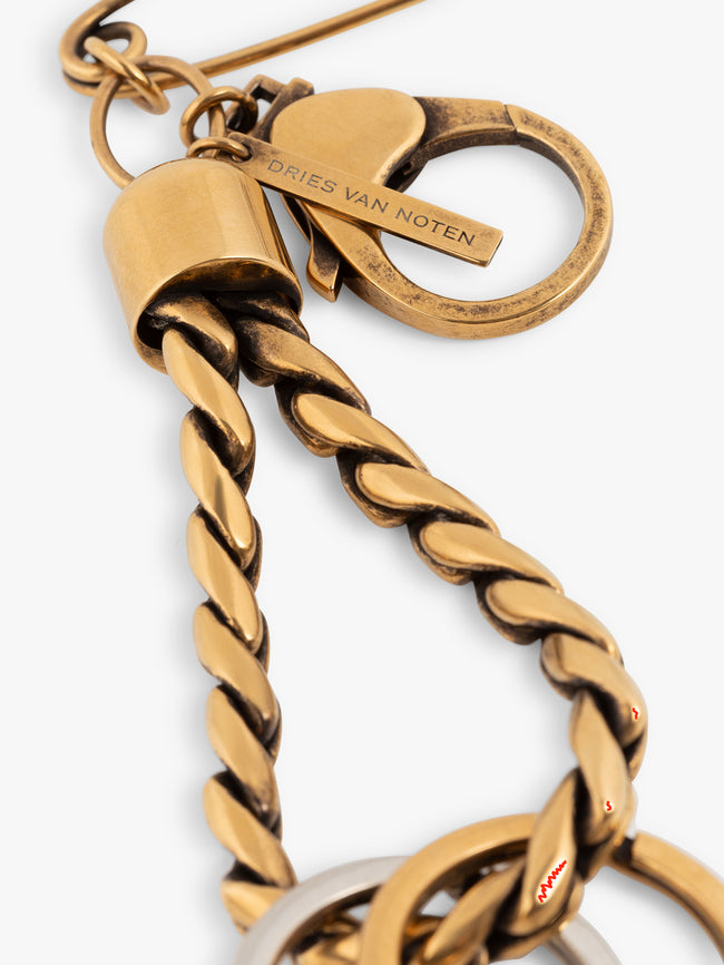 Gold keychain with a safety pin and two rings on a white background