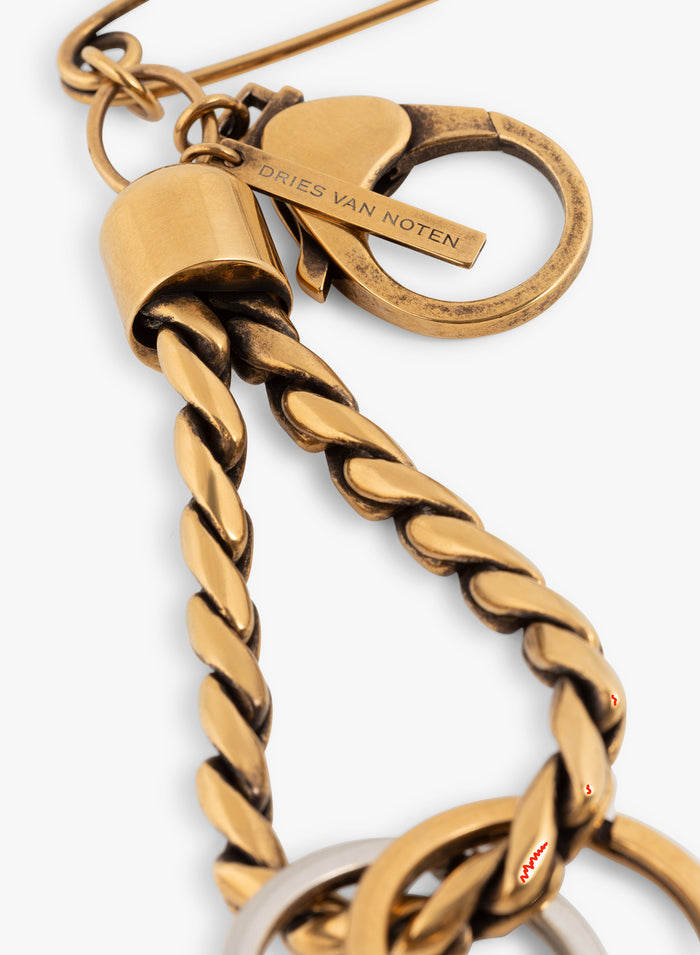Gold keychain with a safety pin and two rings on a white background