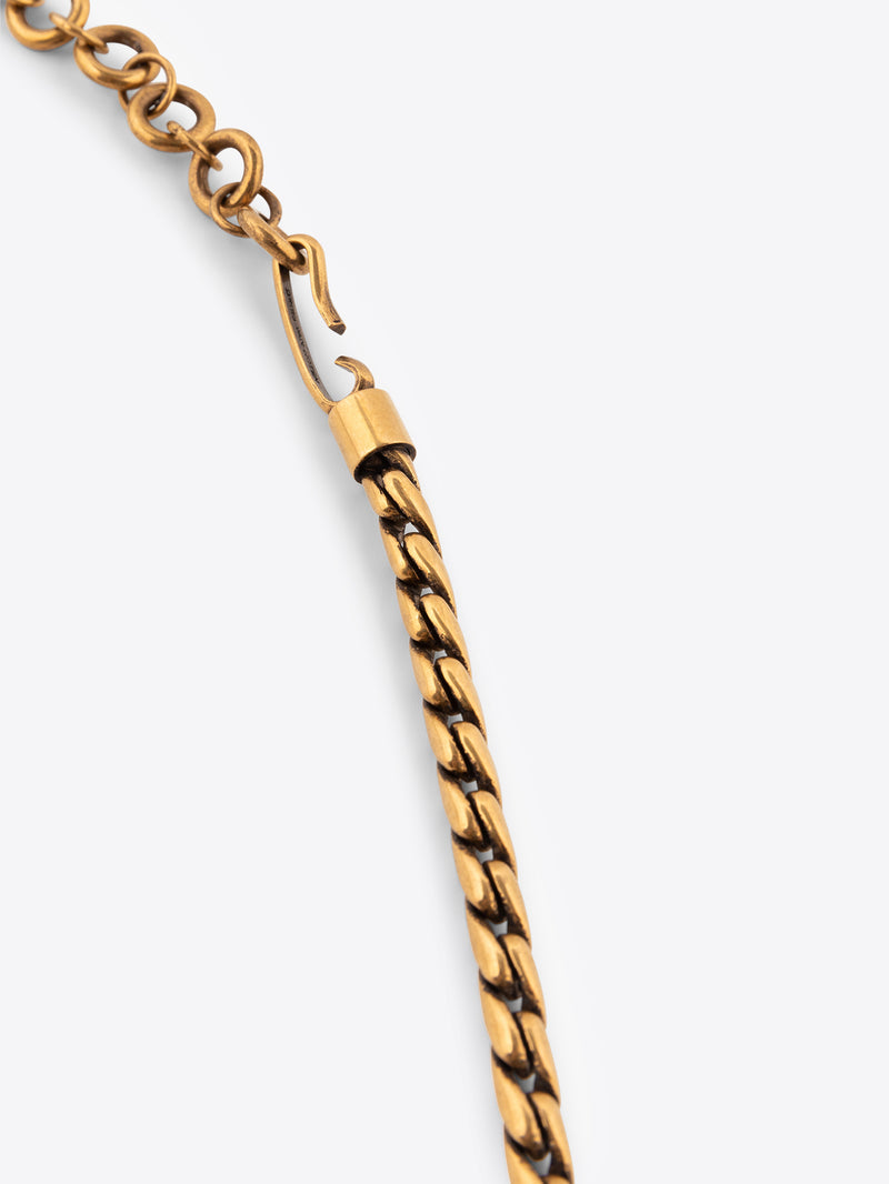 Close up of a gold colored chain belt on a white background