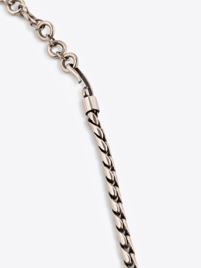 Close up of a palladium chain belt on a white background