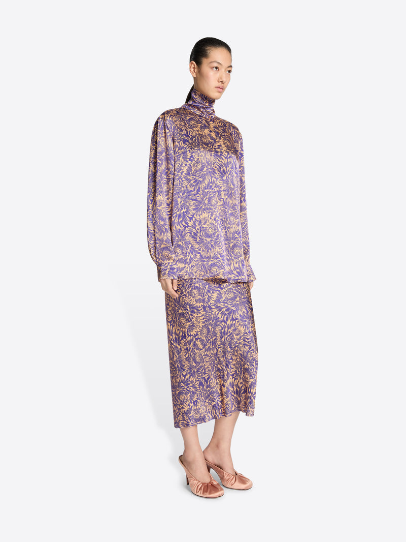 Woman wearing a purple floral dress on a white background