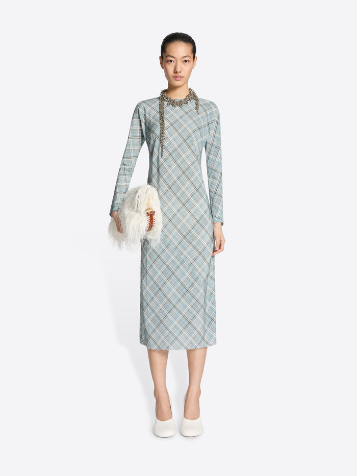 Woman wearing a light blue plaid dress holding a white fur bag on a white background