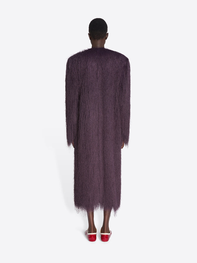 Person wearing a long, dark purple textured coat on a white background - Dries Van Noten